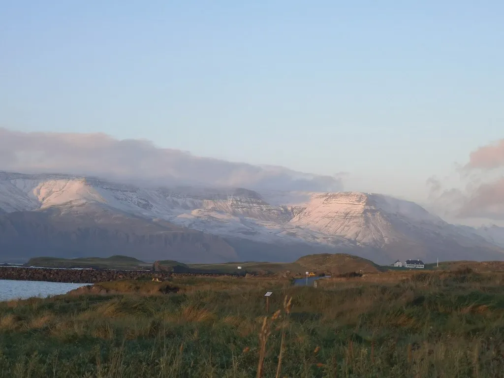 Ośnieżone zbocza góry Esja nad wybrzeżem Reykjavíku w jesiennym świetle