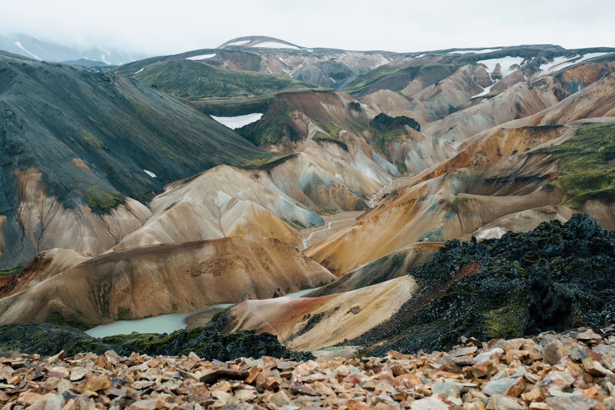Kolorowe ryolitowe góry Landmannalaugar z płatami śniegu, widok ze szlaku na Brennisteinsaldę