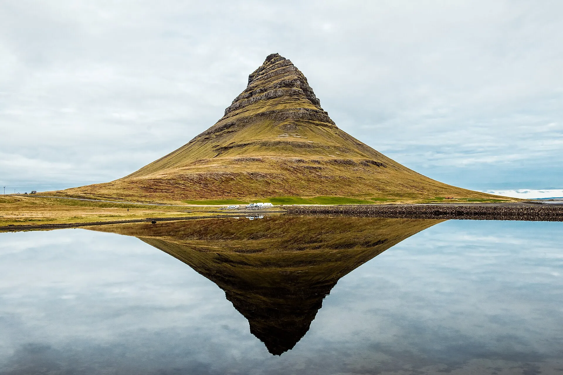 Stożkowata góra Kirkjufell odbijająca się w spokojnej wodzie