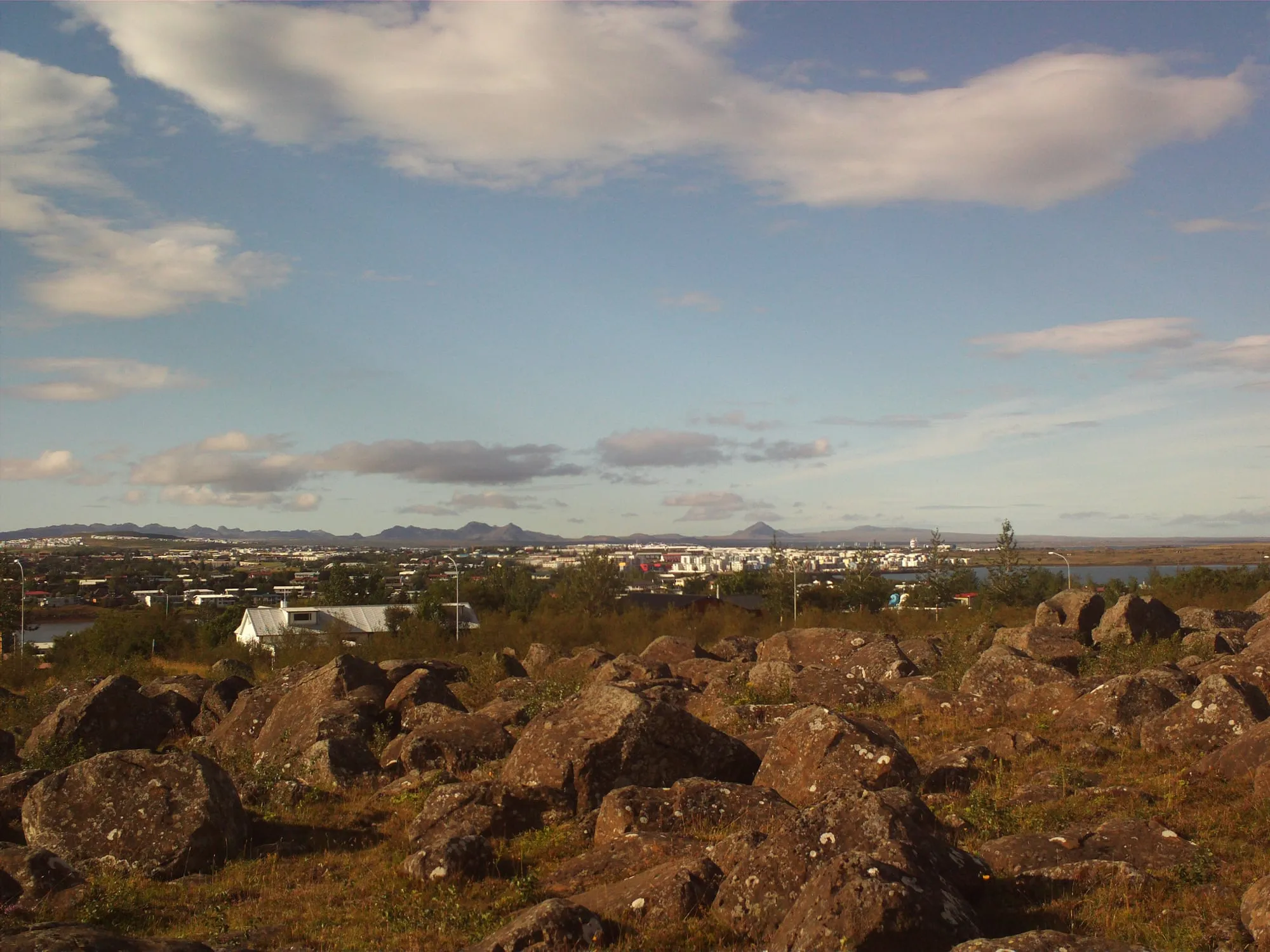 Widok z Kópavogur na zabudowę obszaru stołecznego, zatokę i góry na horyzoncie