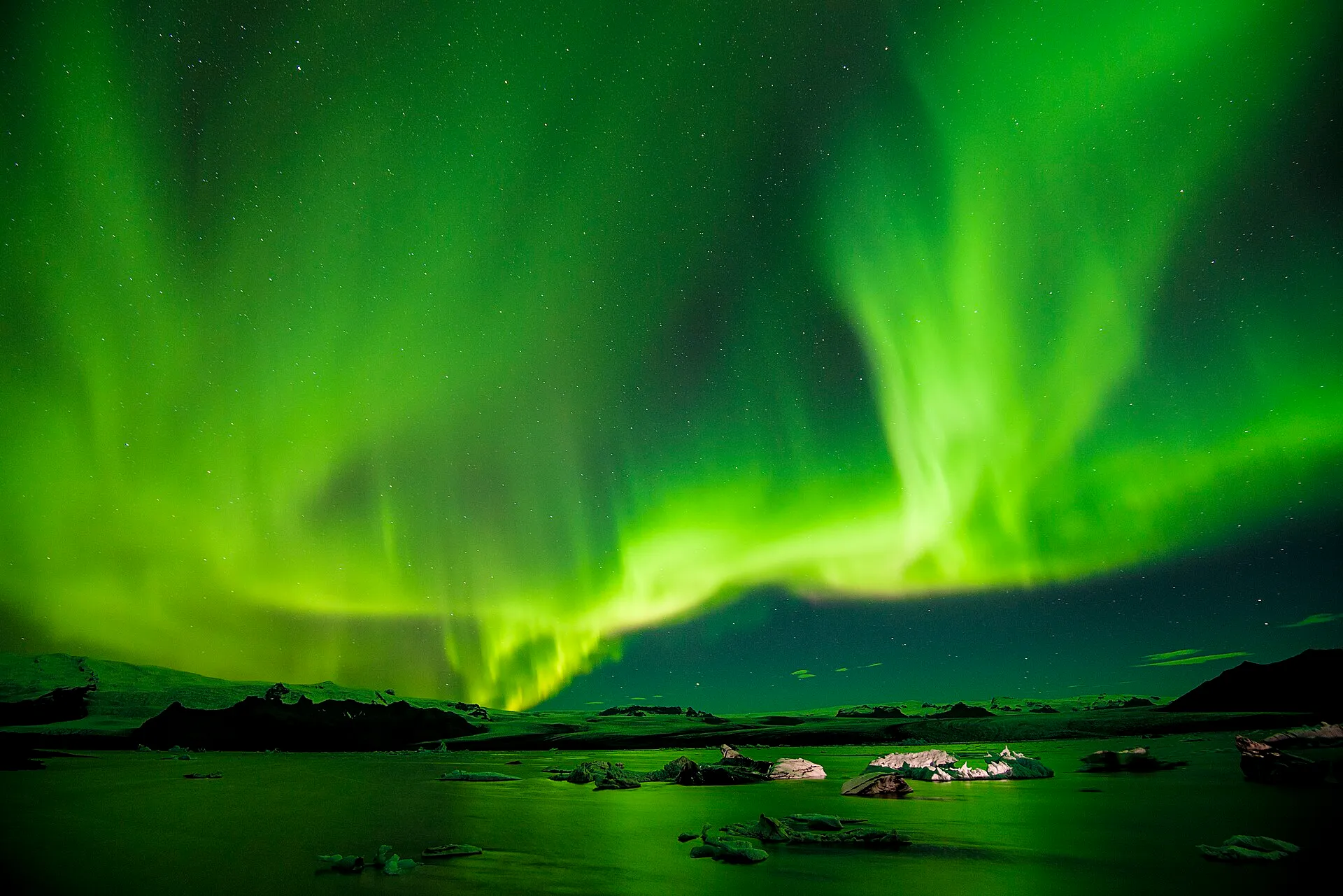 Zorza polarna nad laguną lodowcową Jökulsárlón z krami lodu na wodzie
